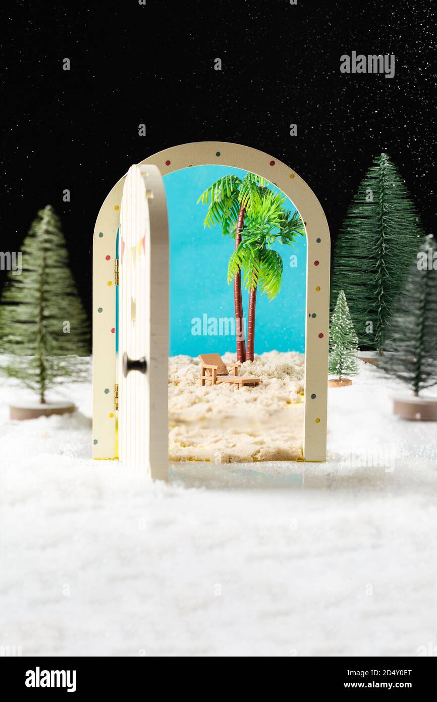 La magia di Capodanno. Albero di Natale, porta in miniatura che si affaccia sulla spiaggia e palme. Foto Stock