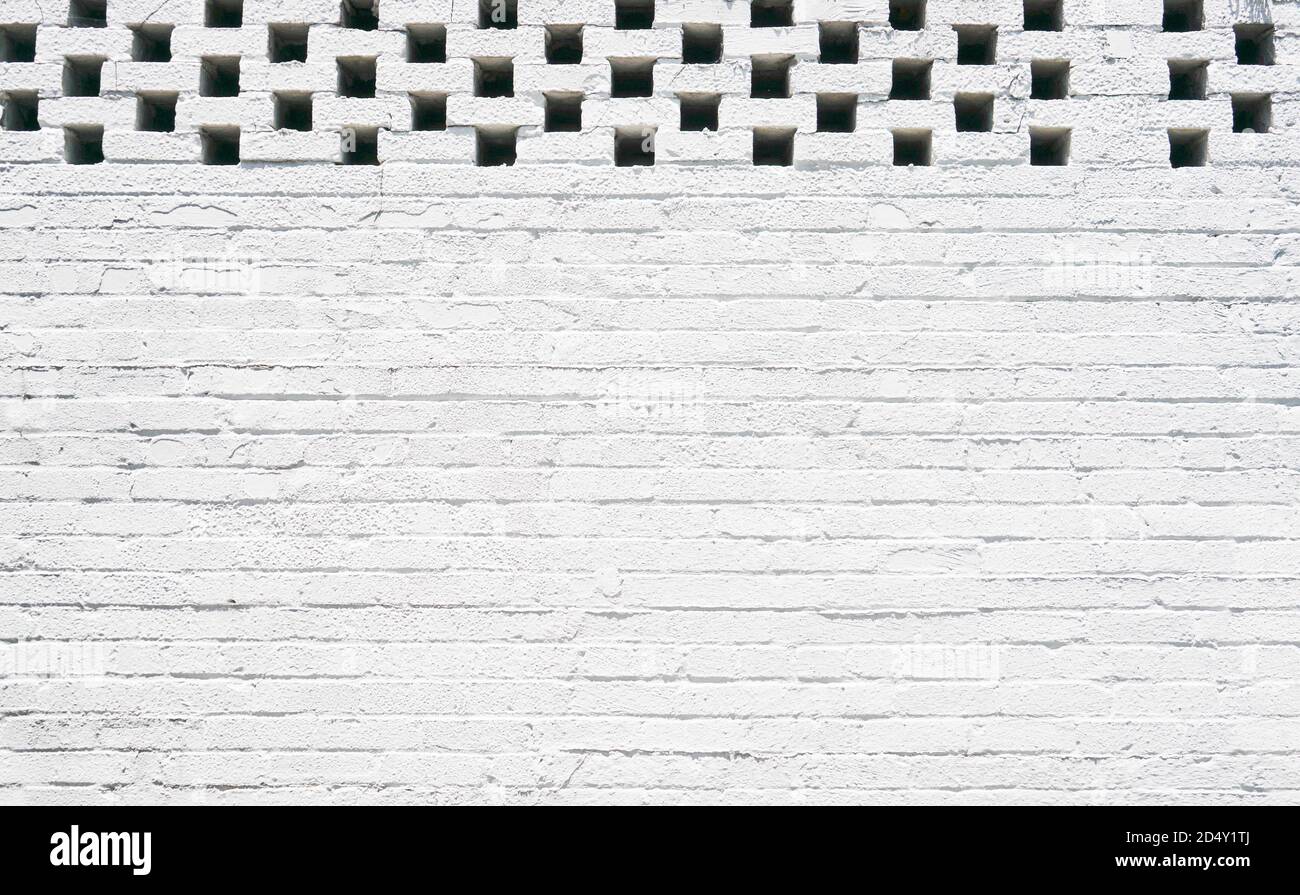 Pareti in mattoni bianchi e neri chiari dall'edificio urbano in città con luci di rilievo Foto Stock