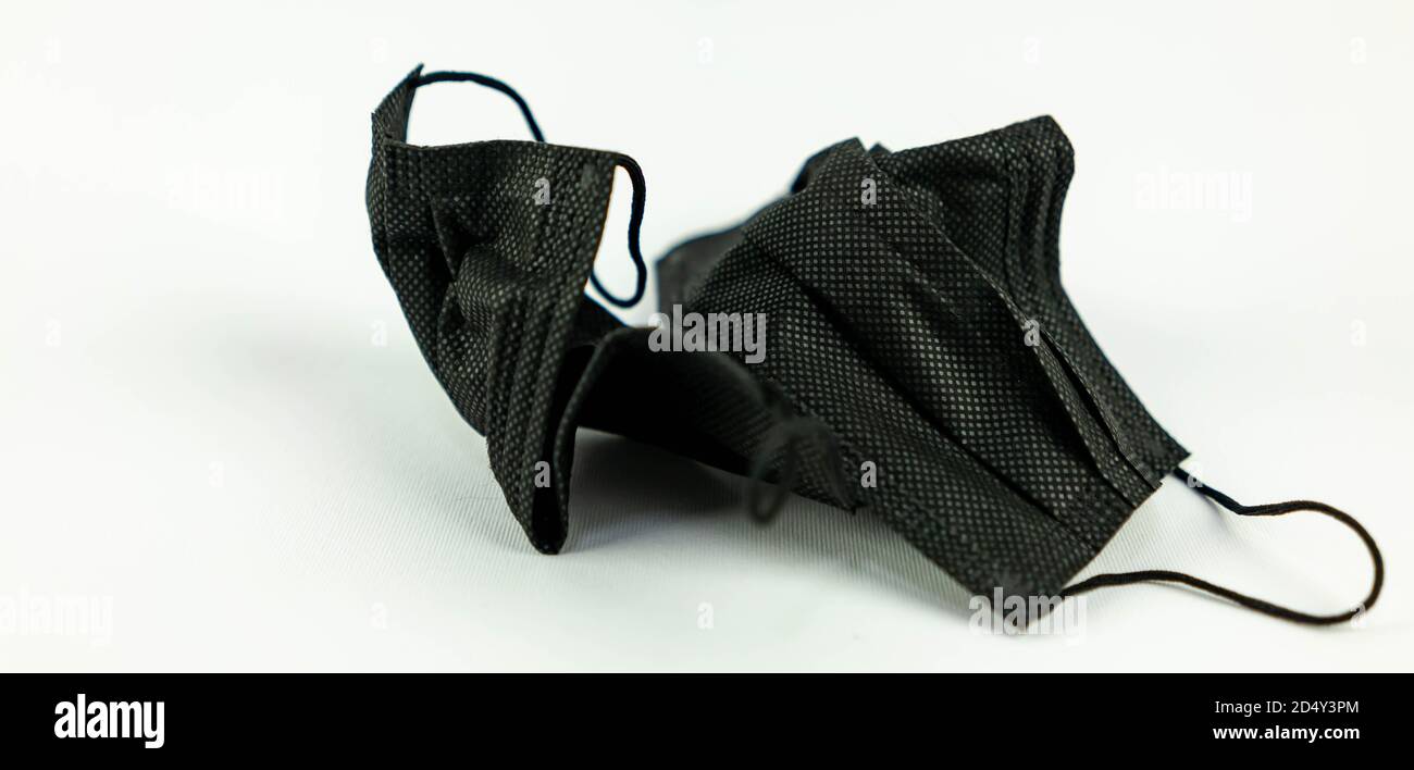 Maschera chirurgica usata gettata sul pavimento bianco. Maschera utilizzata per la protezione Covid 19 non smaltita correttamente e gettata ovunque Foto Stock