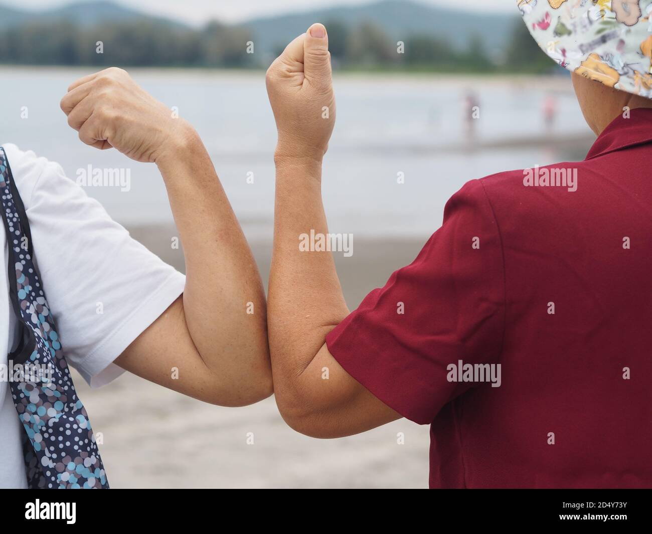 Due donne alternative handshakes Elbow Bump saluto nella situazione di un'epidemia covid 19, coronavirus nuovo normale di allontanamento sociale Foto Stock