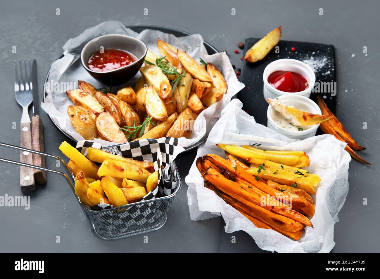 Diversi tipi di patate fritte . Spicchi di patate, patatine fritte, patate dolci. Foto Stock