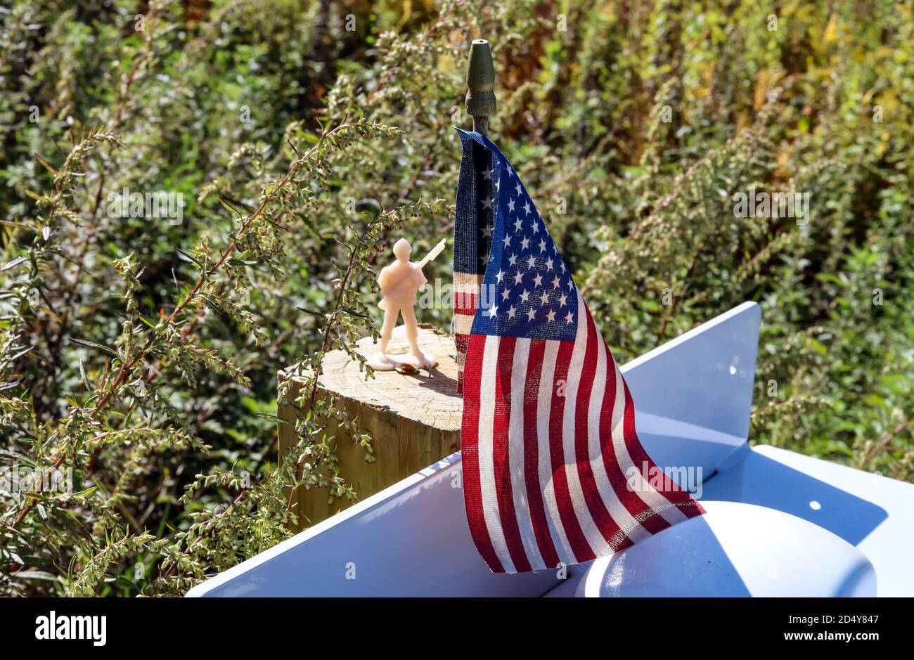 Un'esposizione patriottica di un soldato giocattolo in piedi fiero vicino ad una piccola bandiera degli Stati Uniti. Foto Stock
