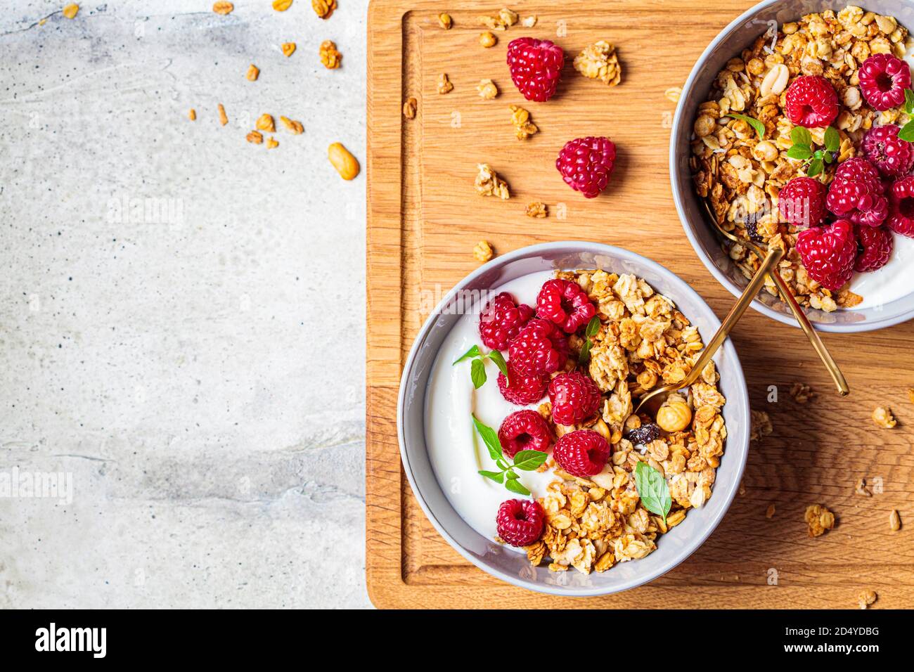 Muesli con lamponi e yogurt in una ciotola grigia. Concetto di cibo sano. Foto Stock