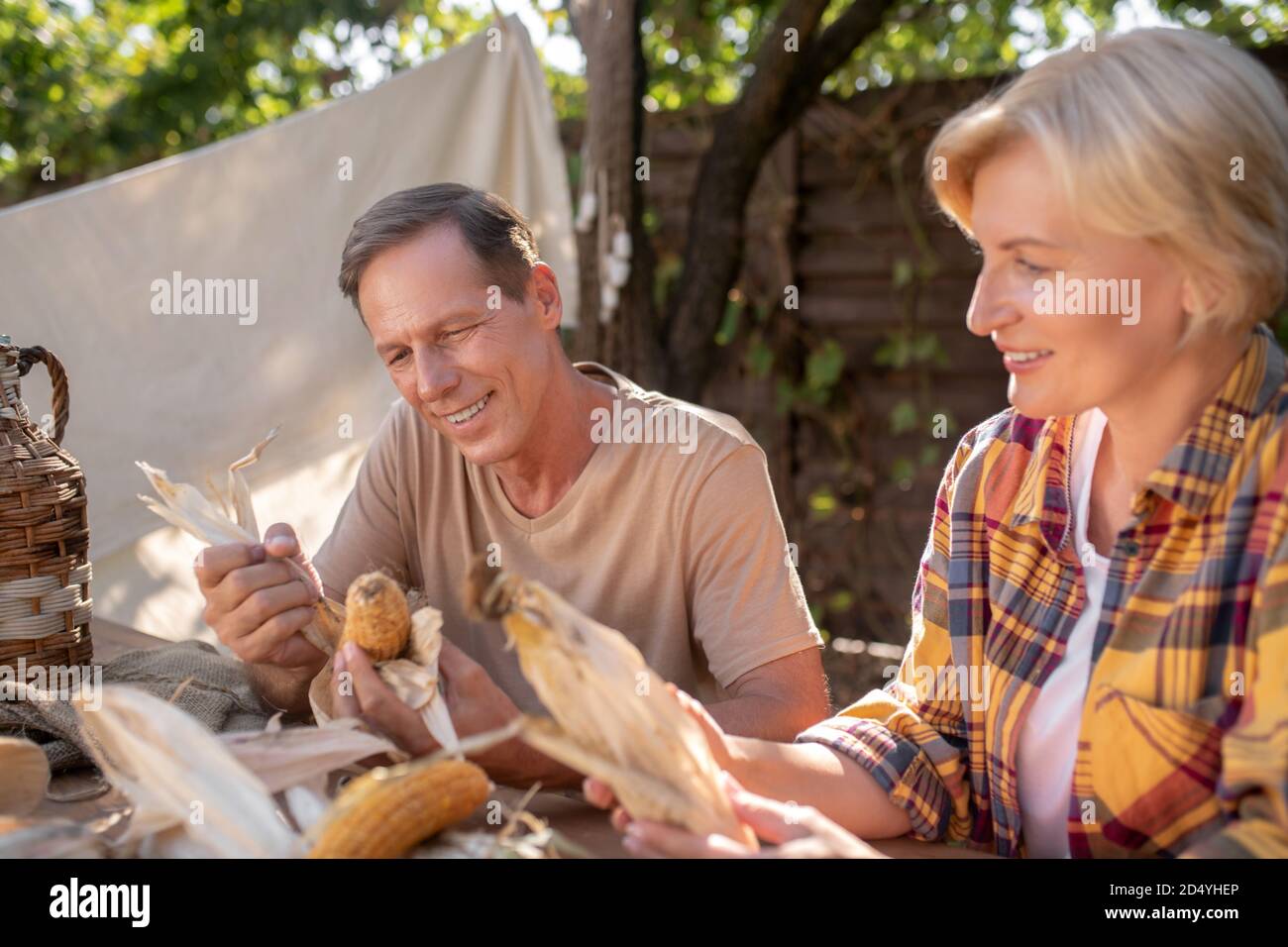 Sorridente coppia di mezza età seduta al tavolo, cazzo di mais Foto stock -  Alamy