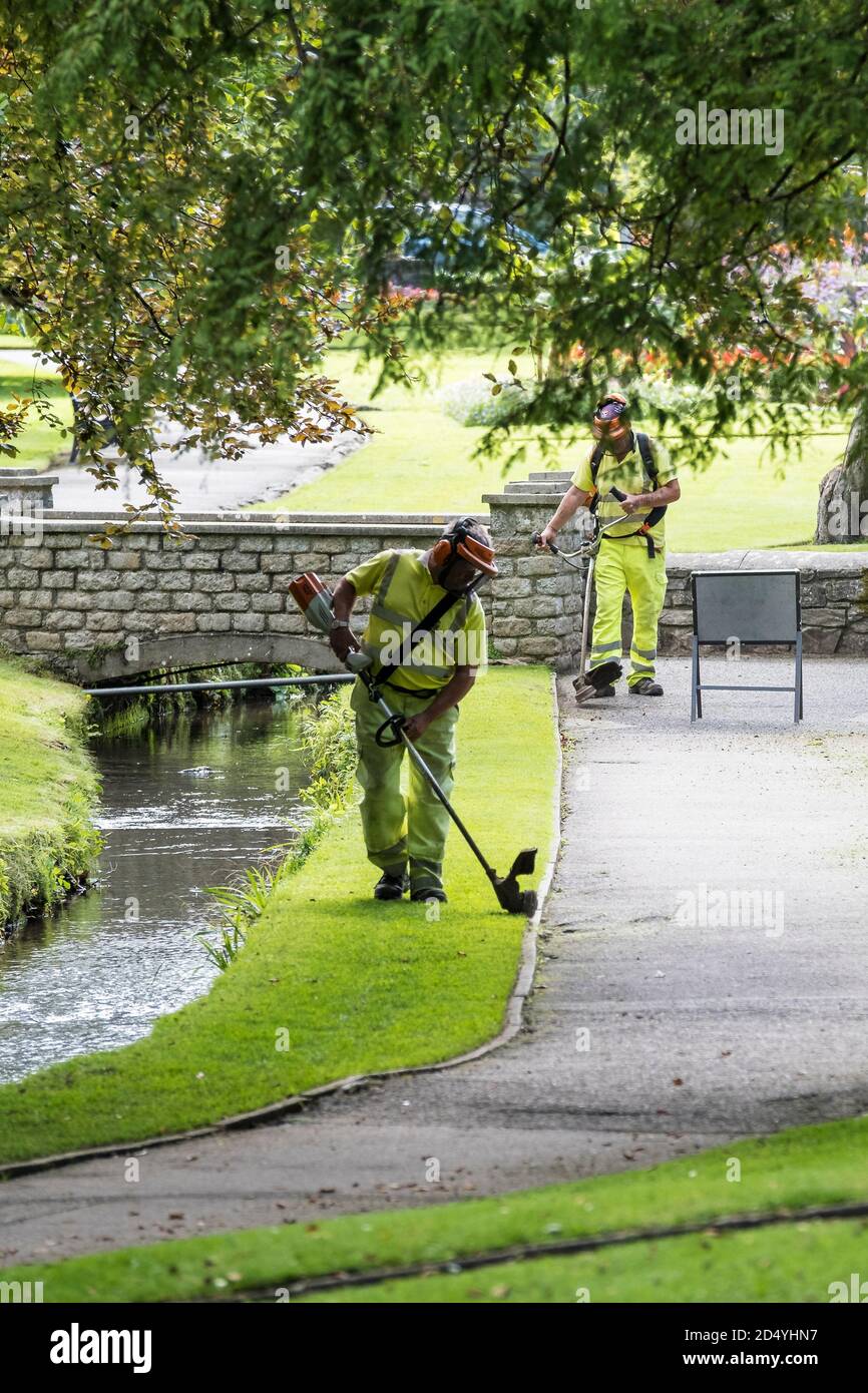 Lavoratori Cormac striping erba in Trenance Gardens a Newquay in Cornovaglia. Foto Stock