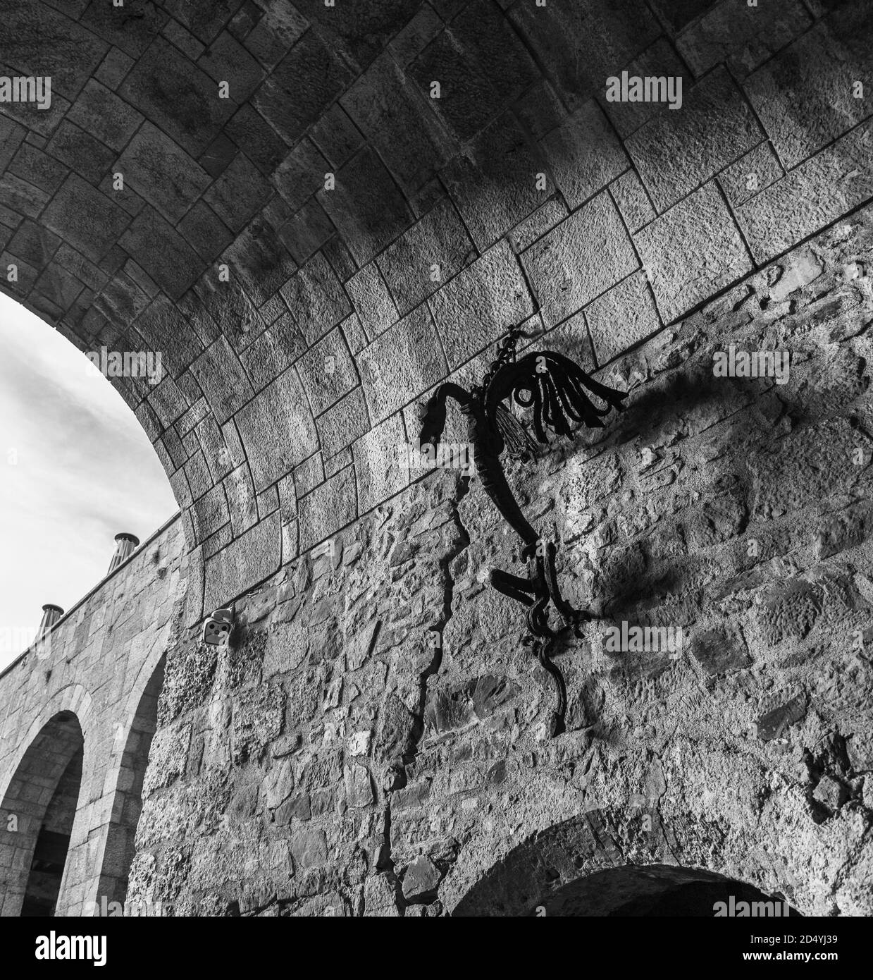 Immagine in bianco e nero di un drago decorativo in metallo attaccato al tunnel d'ingresso del Castello di Lubiana. Foto Stock