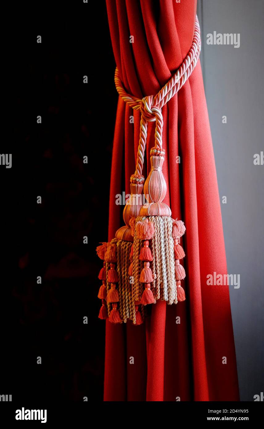 sontuoso tessuto a tenda in velluto rosso e nappine decorative in corda in periodo interno casa inglese Foto Stock