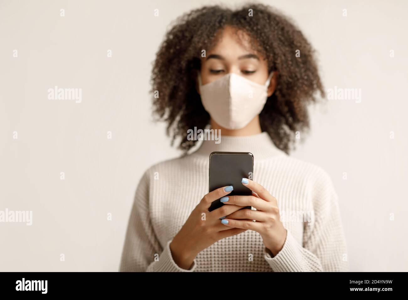 Notizie sulla diffusione del virus nel mondo e sui social network. afroamericani dama scrivere sullo smartphone Foto Stock