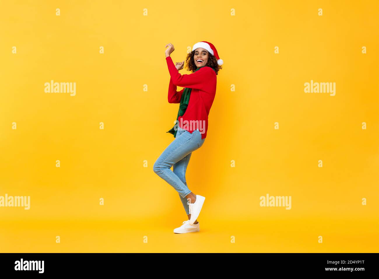 Ritratto a lunghezza intera di divertente donna felice in abbigliamento di Natale ballare su isolati sfondo giallo studio Foto Stock
