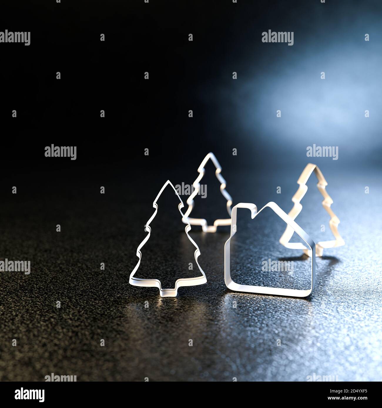 Concetto di bene immobile di Natale: Una taglierina a forma di casa del biscotto e tre taglienti del biscotto dell'albero di Natale che si levano in piedi su una piastra metallica nera. Spazio di copia, selec Foto Stock