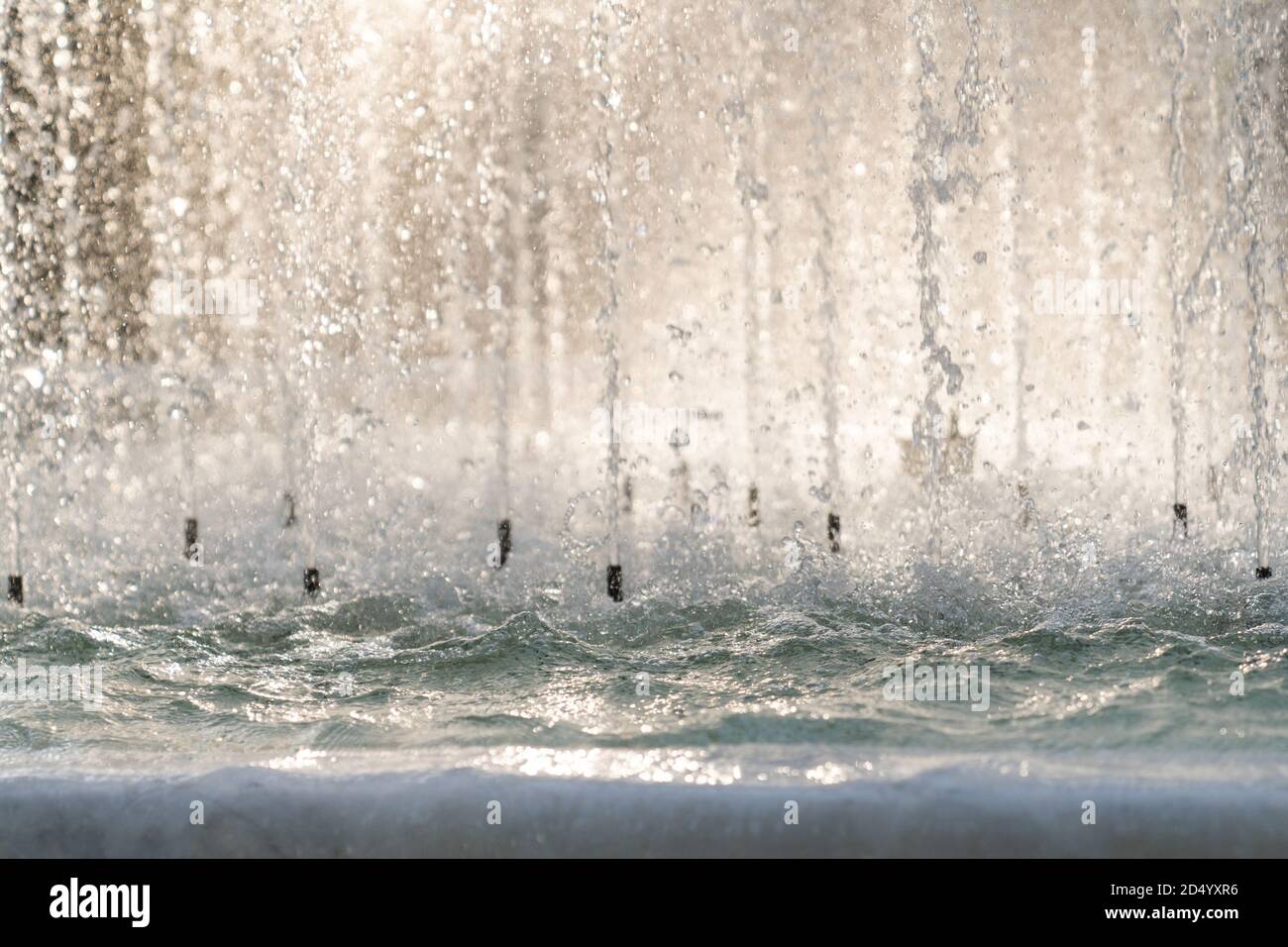 Primo piano di spruzzi d'acqua nella fontana al tramonto. Foto Stock