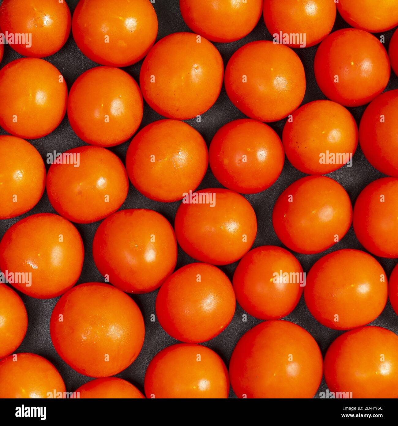 alcuni pomodori piccoli su un tavolo nero Foto Stock
