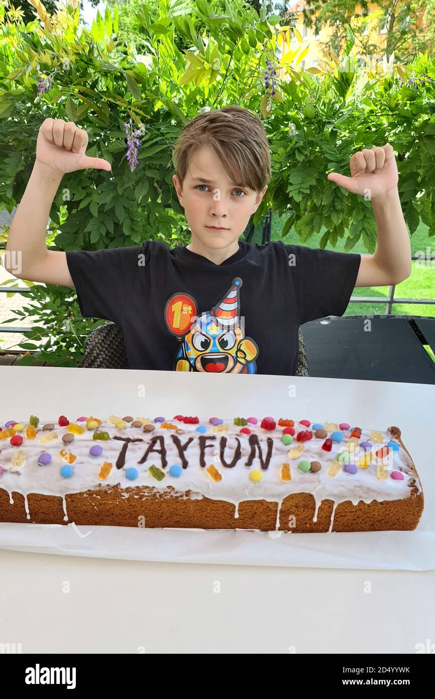 Ragazzo con torta di compleanno punta a se stesso, Germania Foto Stock