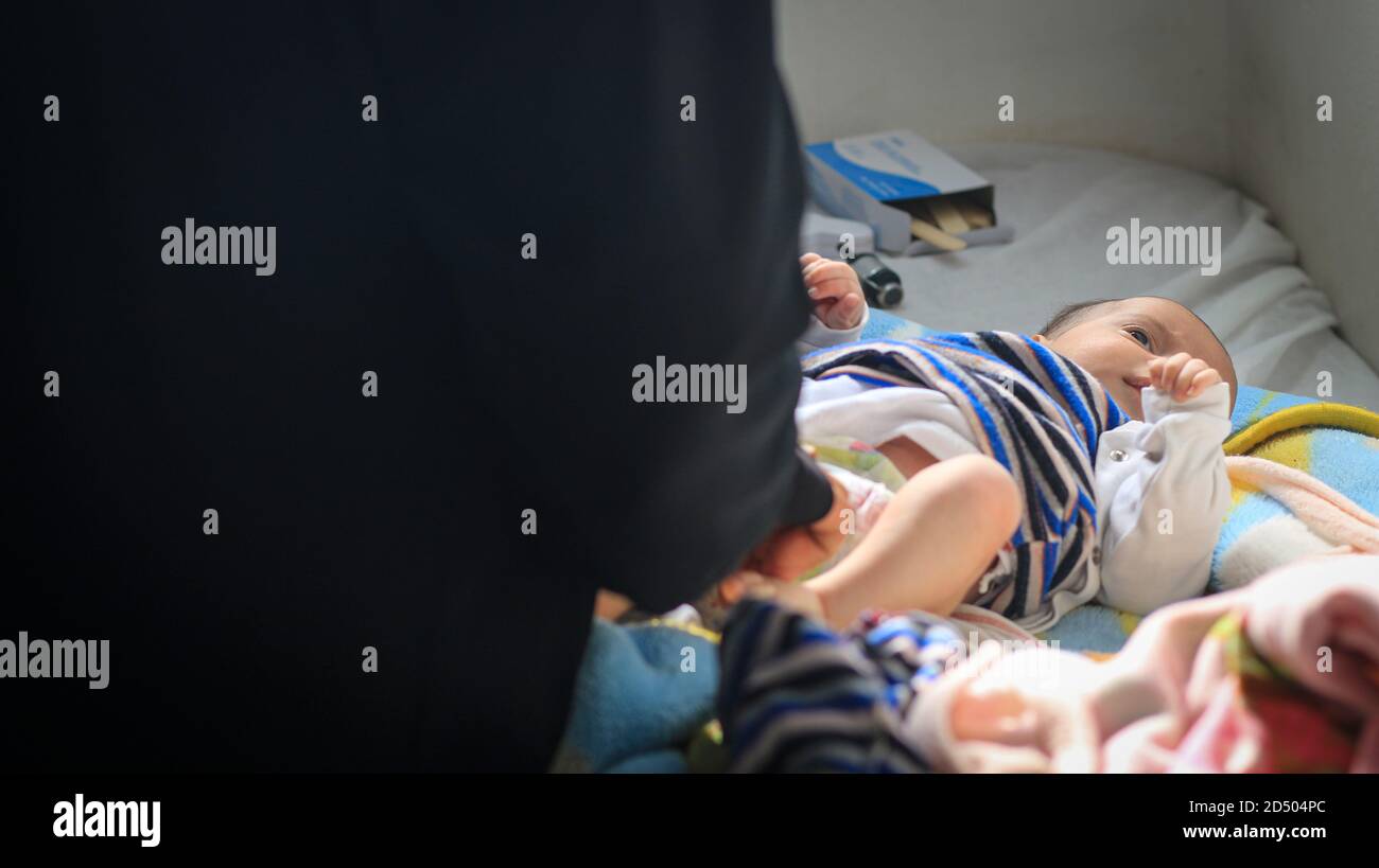 Un bambino malato si trova su un letto d'ospedale. Foto Stock