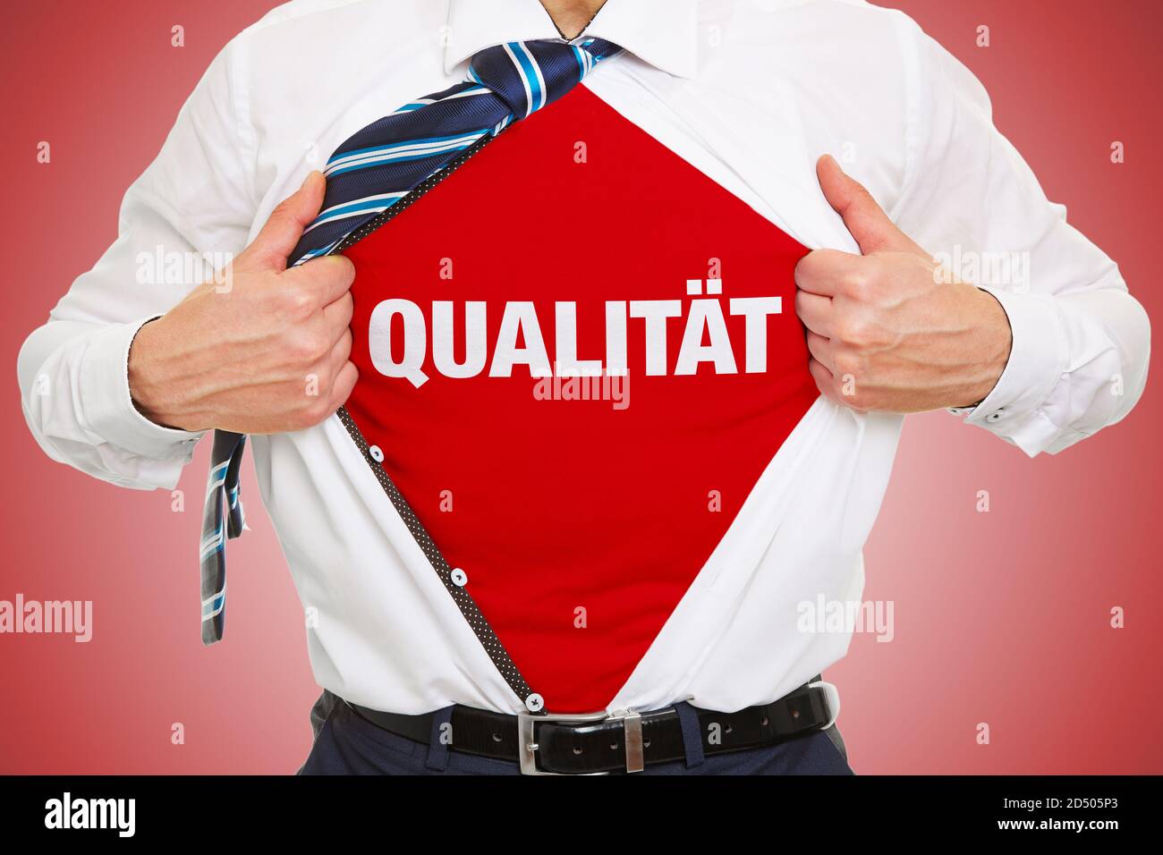 L'uomo d'affari apre la camicia e indossa scritte Qualität (tedesco per: Qualità) sotto come concetto Foto Stock