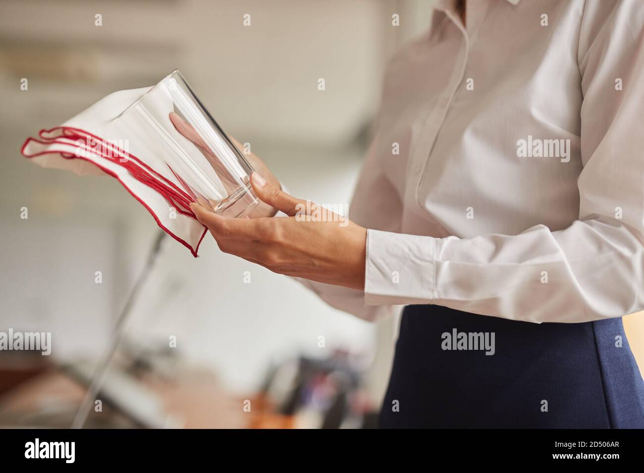 Primo piano di un'assistente femminile irriconoscibile che puliva il vetro mentre preparava la sala conferenze per un evento d'affari, spazio fotocopie Foto Stock