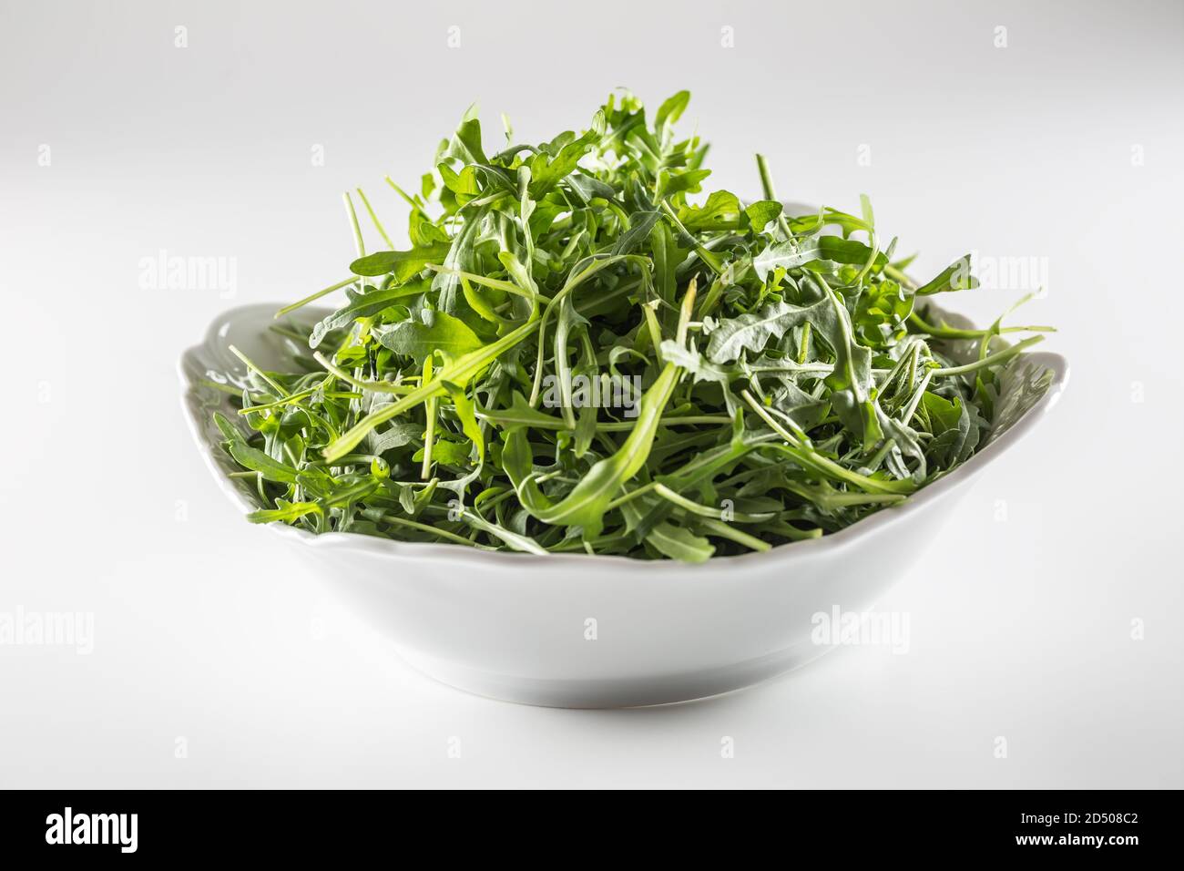 Ciotola piena di foglie di insalata su uno sfondo isolato Foto Stock