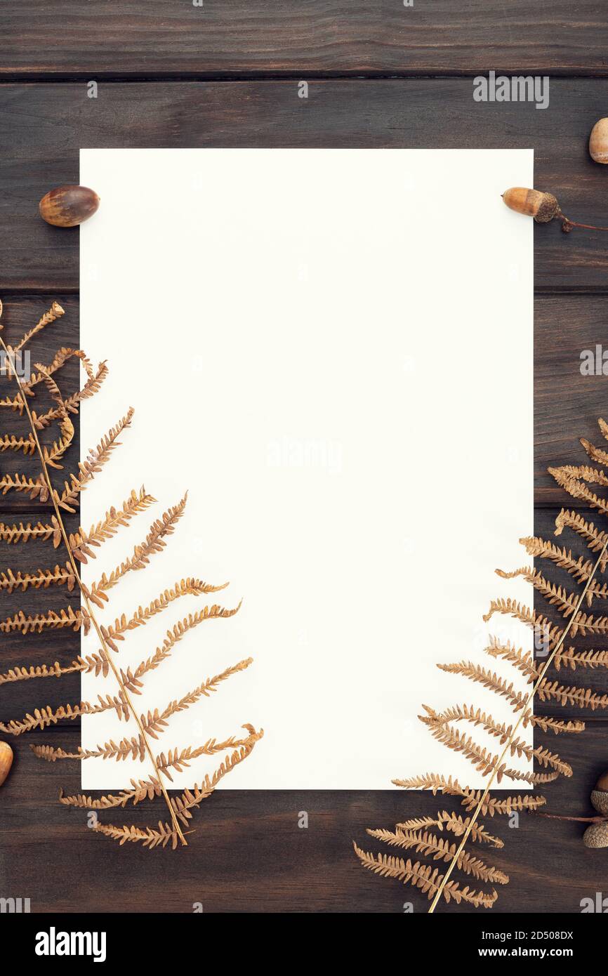 Carta bianca su tavola di legno e decorazione autunnale. Modello, Mock-up. Autunno sfondo. Vista dall'alto Foto Stock