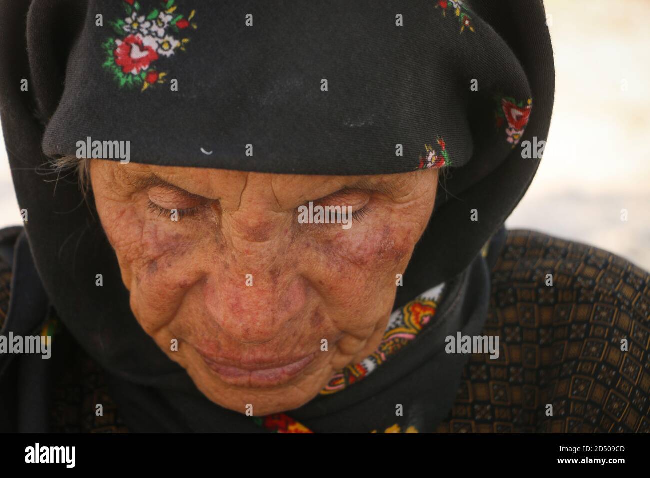 Una donna anziana grida a causa della perdita del figlio, lacrime che sgorgano giù il viso di una donna anziana, rughe sul volto di una donna anziana, primo piano Foto Stock