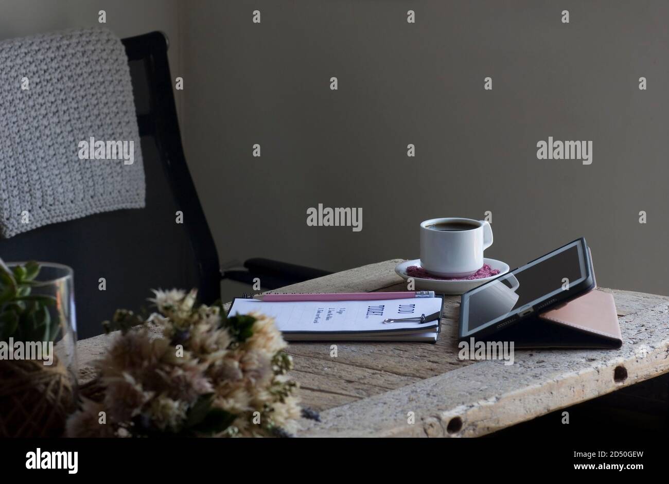 Accogliente ufficio domestico con una scrivania in legno rigenerata in toni di crema e rosa Foto Stock