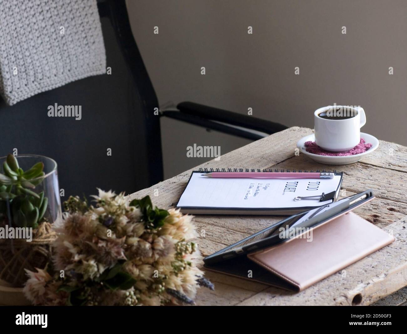 Accogliente ufficio domestico con una scrivania in legno rigenerata in toni di crema e rosa Foto Stock