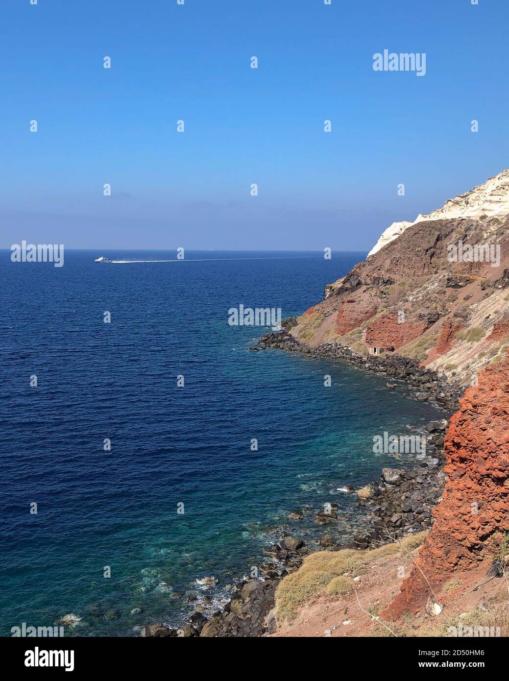 Vista di una costa greca frastagliata durante il giorno. Intorno alla baia di Amoudi, sull'isola di Santorini in Grecia. Foto Stock