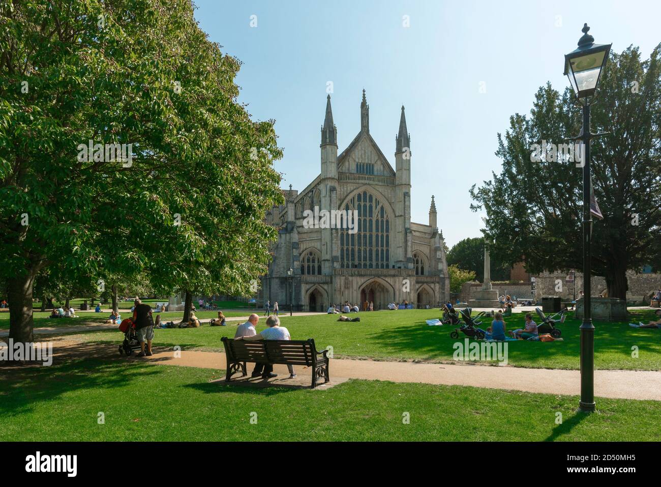 Winchester Cathedral, vista in estate delle persone che si rilassano nei giardini della cattedrale nel centro di Winchester, Hampshire, Inghilterra, Regno Unito Foto Stock