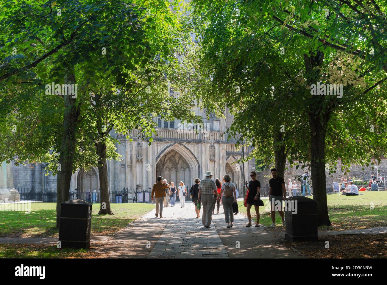 Città estiva del Regno Unito, vista in estate di persone che camminano attraverso i terreni della cattedrale nella città Hampshire di Winchester, Inghilterra, Regno Unito. Foto Stock