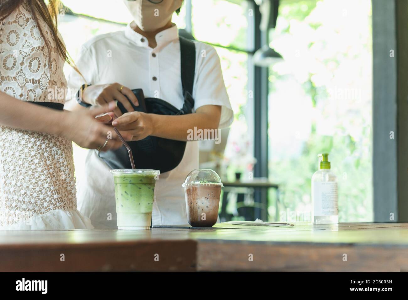 Nuovo normale piccola impresa freddo tè verde matchd e mocha ghiacciato in tazza di plastica sul tavolo nel caffè. Foto Stock