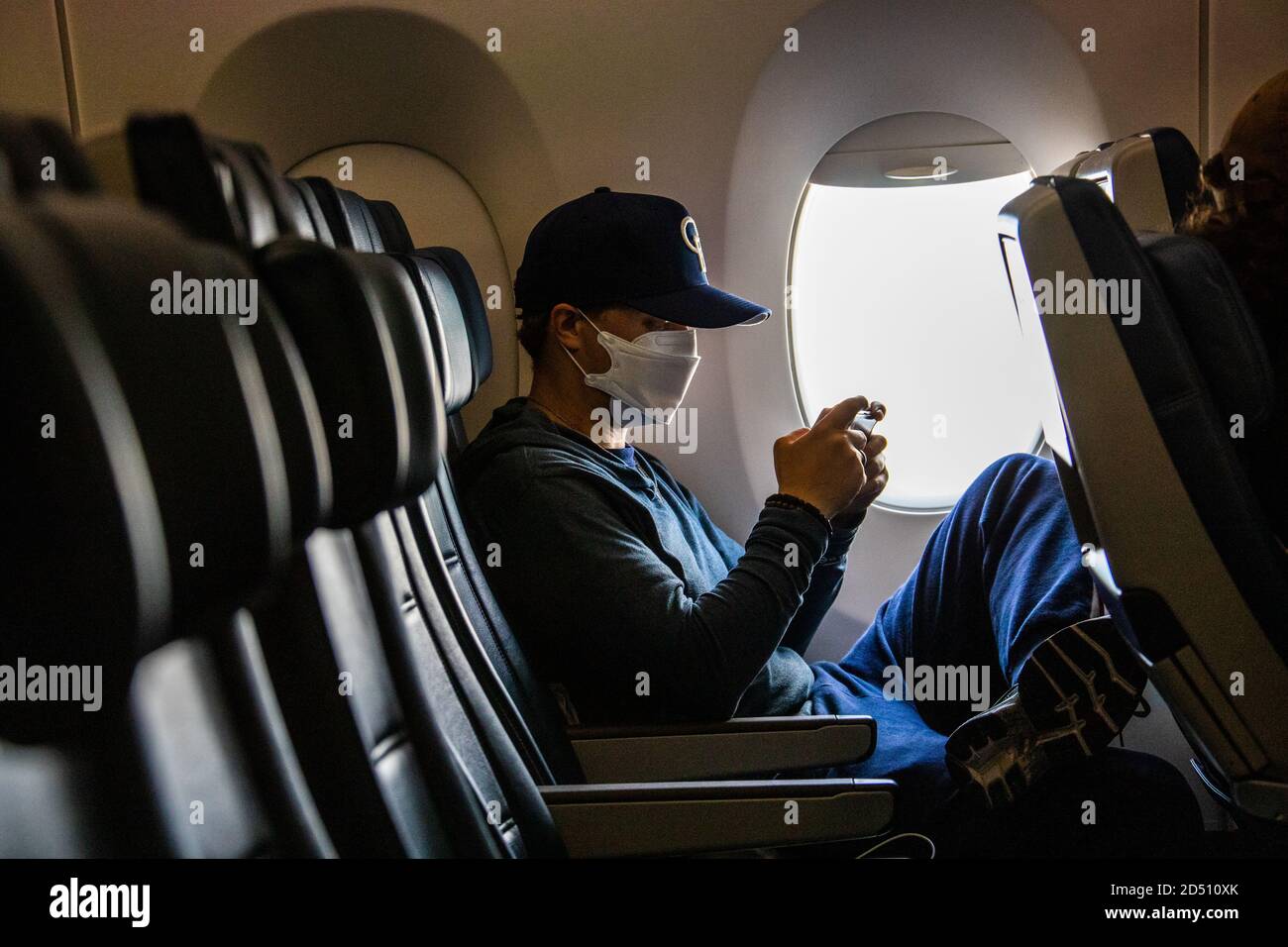 Passeggero su un volo internazionale quasi vuoto che indossa una maschera Per proteggere da COVID-19 Foto Stock