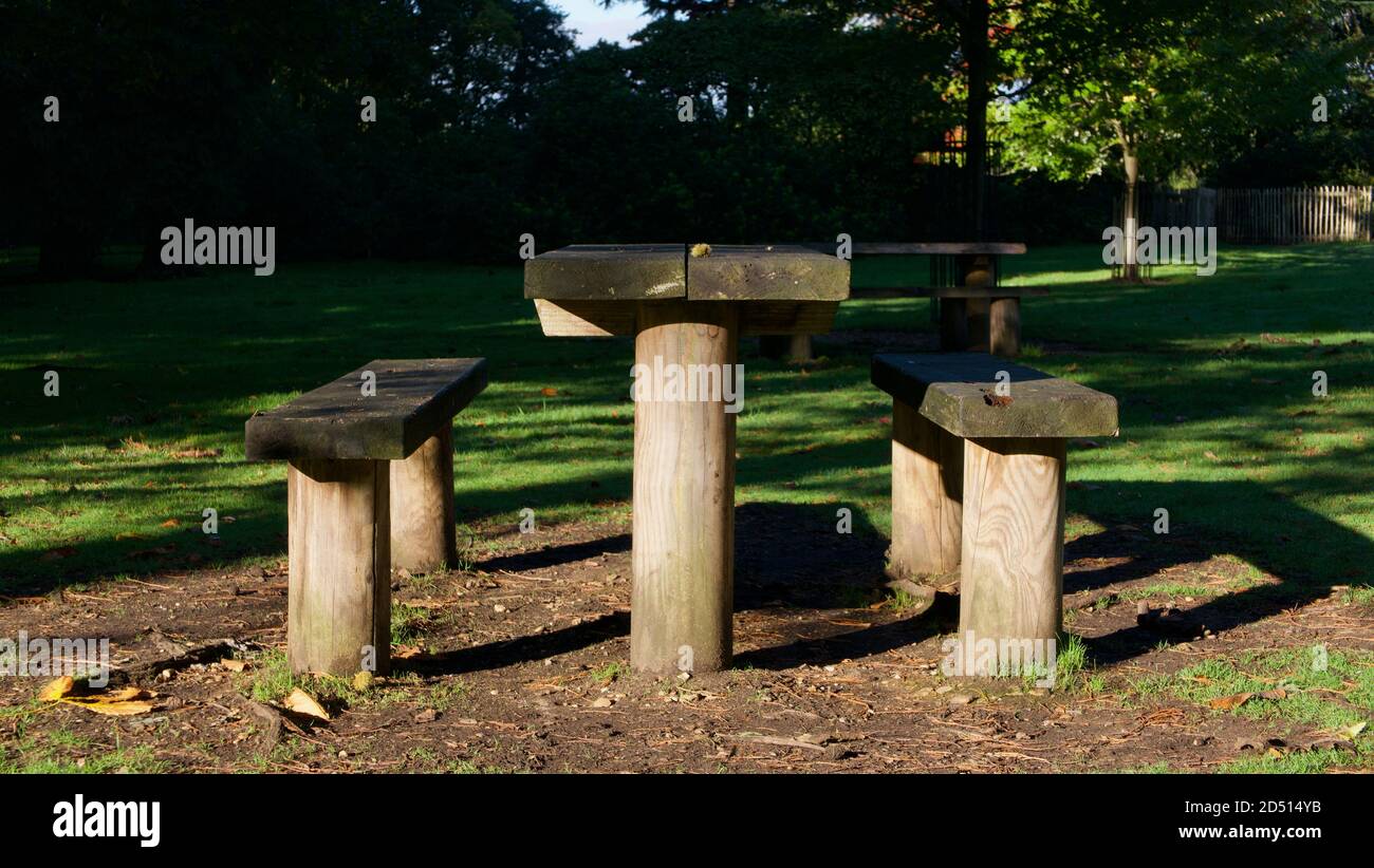 Semplice tavolo in legno e panche in legno nel parco in autunno Foto Stock