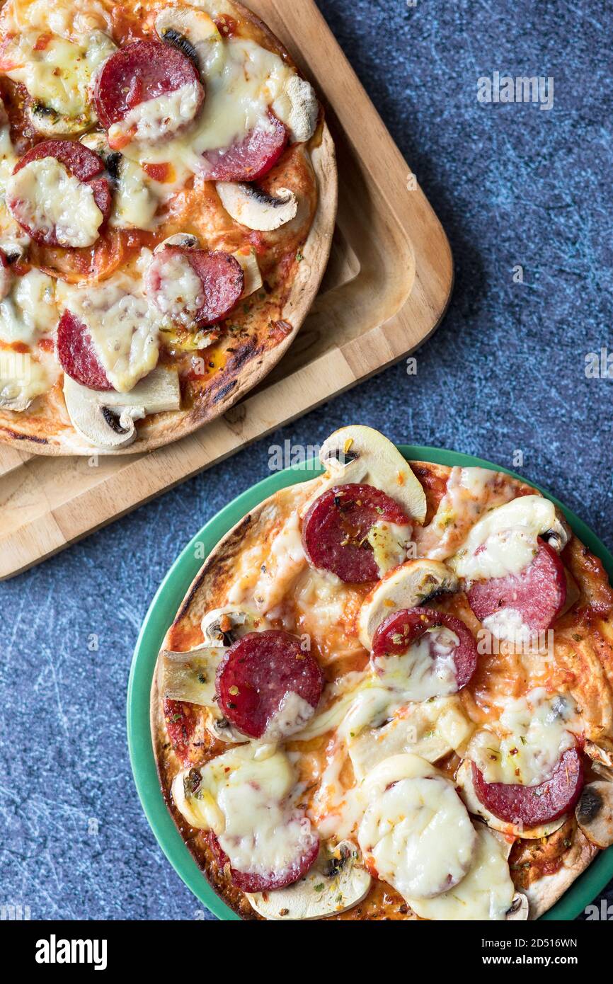 Due pizze di peperoni con mozzarella, funghi bianchi e sriracha Foto Stock