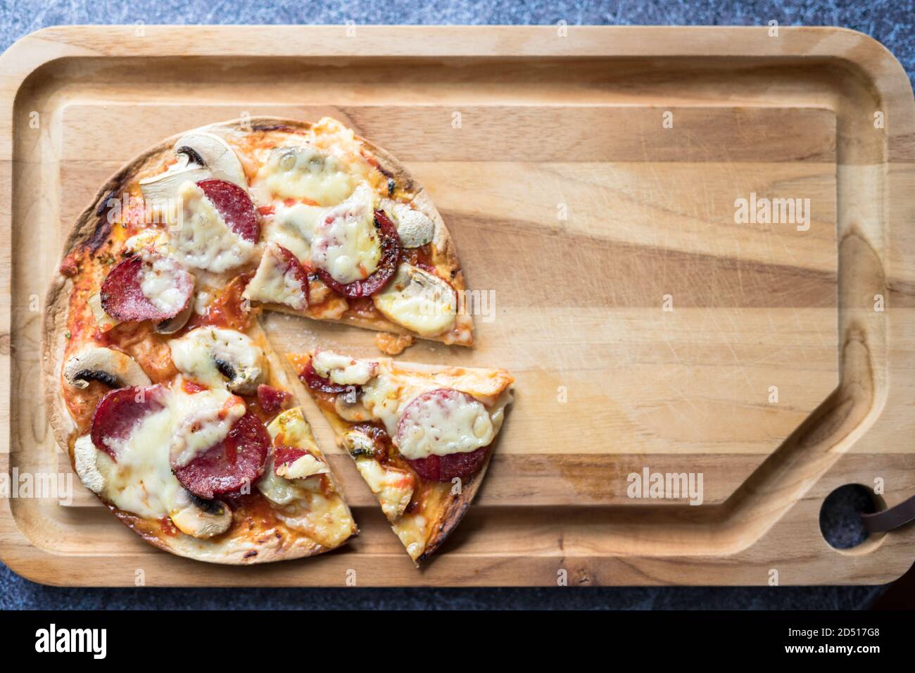 Pizza salame a fette con mozzarella, funghi bianchi e sriracha Foto Stock