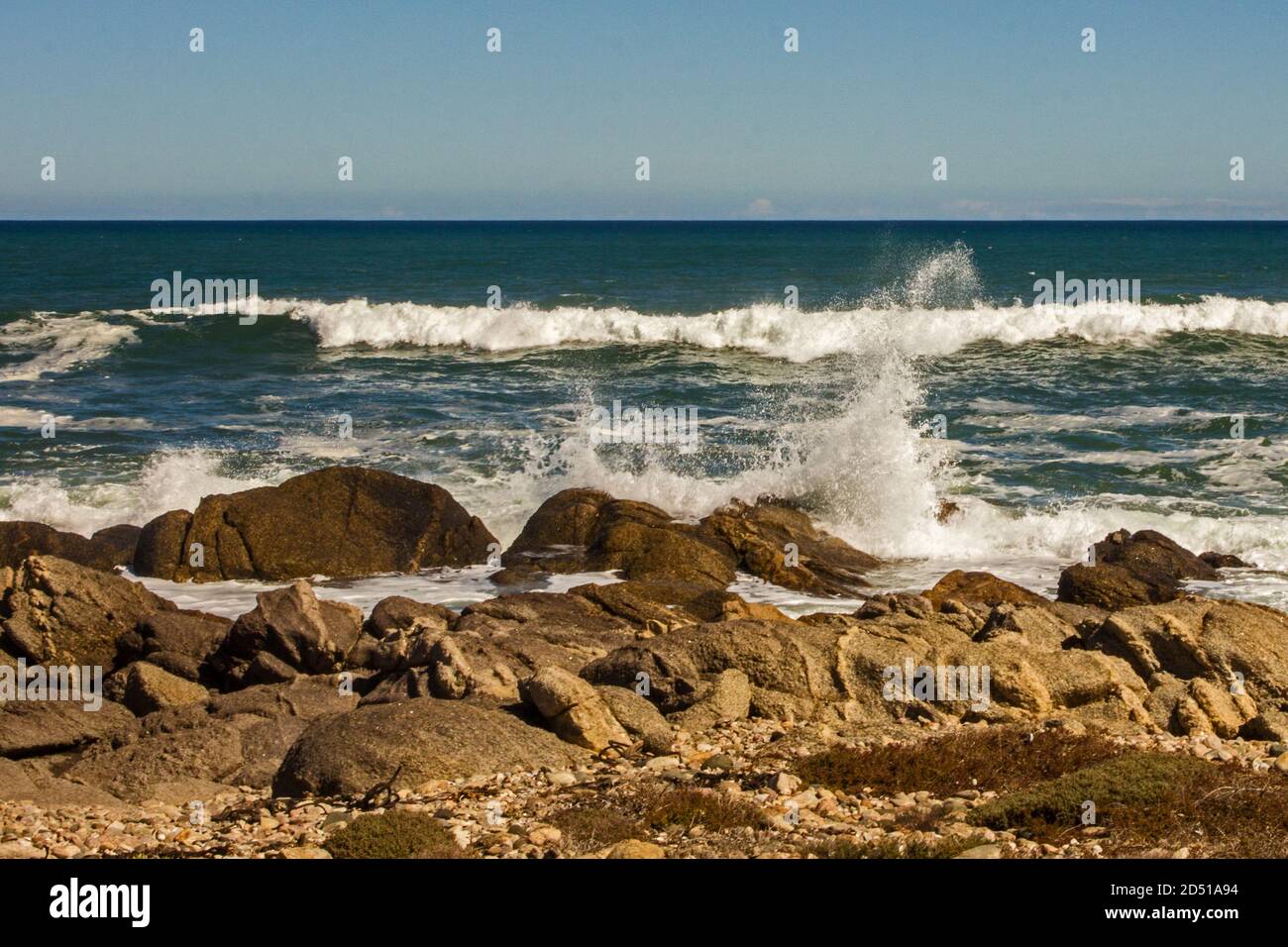 Un oceano agitoso con onde che si infrangono spettacolari contro i massi sulla riva della sezione costiera del Parco Nazionale di Namaqua, Sud Africa Foto Stock