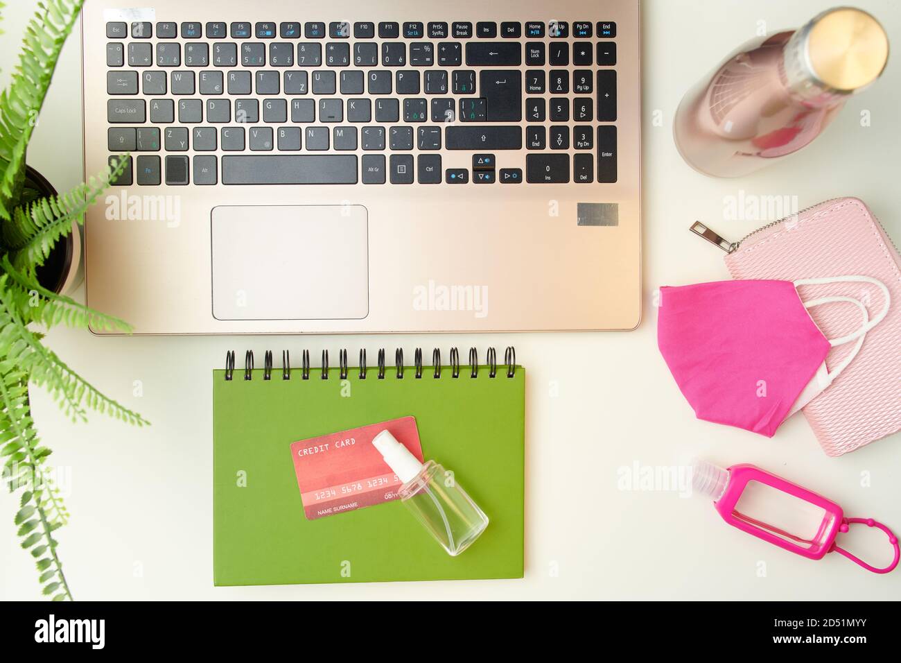 coronavirus piatto con portafoglio, laptop, carta di credito, maschera medica e notebook con antisettico su sfondo bianco. Foto Stock