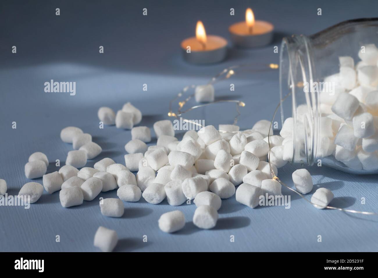 marshmallows in un vaso di vetro su sfondo azzurro Foto Stock