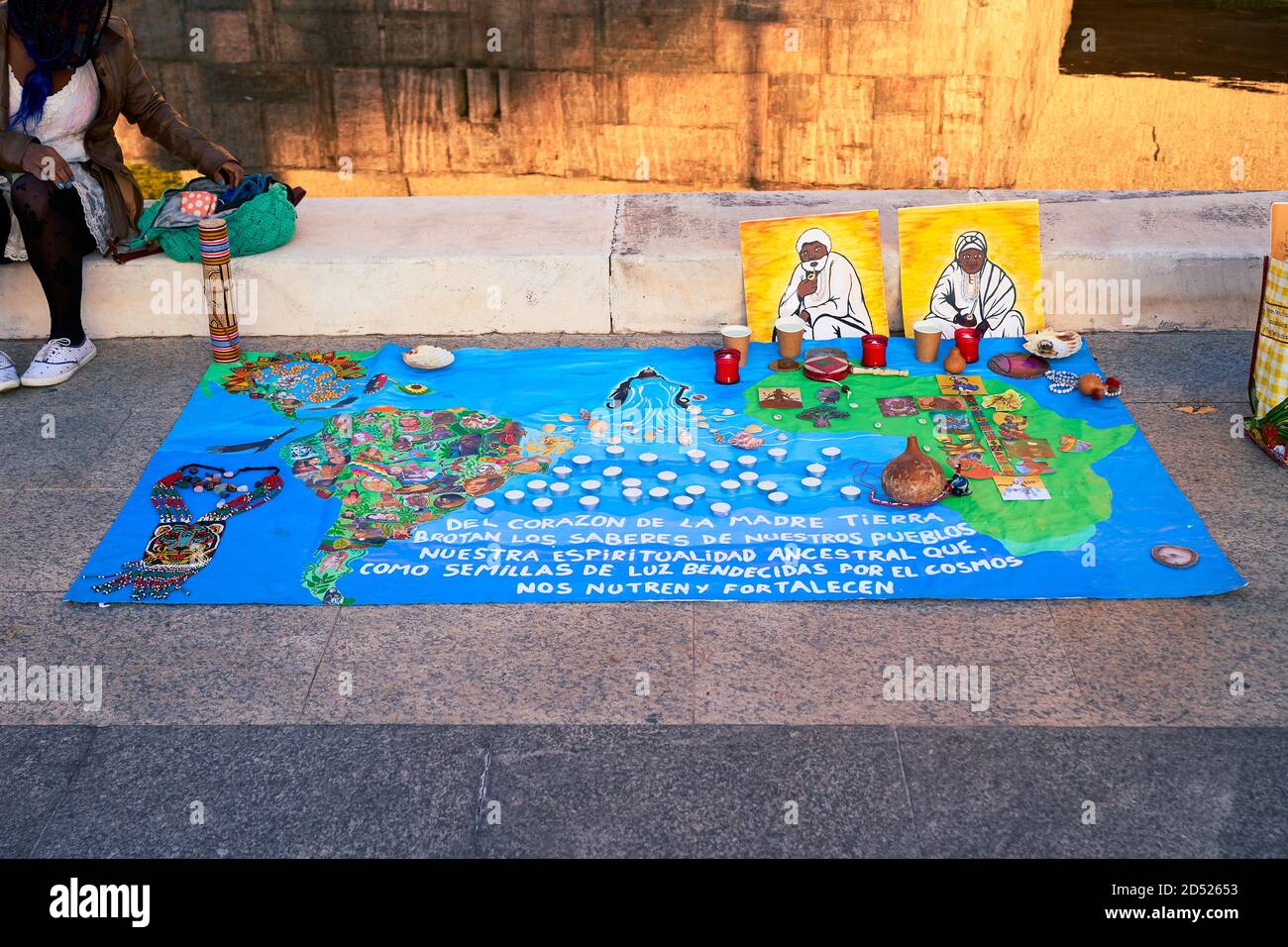 Banner blu a forma di mappa con la scritta "Del corazon de la Madre Tierra" con candele e due ritratti posati a terra, Plaza de Colon, Madrid, ottobre 2020 Foto Stock