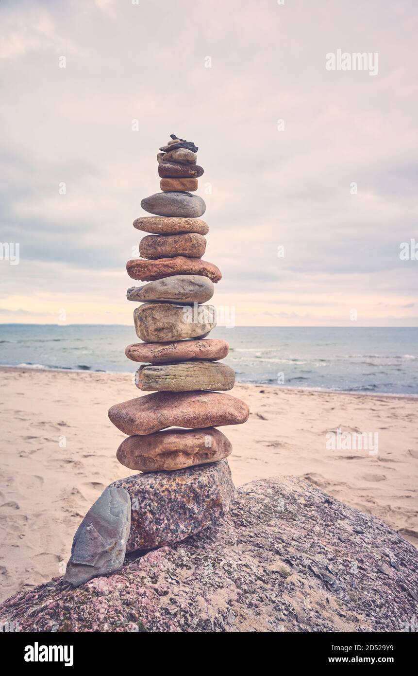 Piramide di pietra su una spiaggia, zen, armonia e concetto di equilibrio, tonalità di colore applicato. Foto Stock