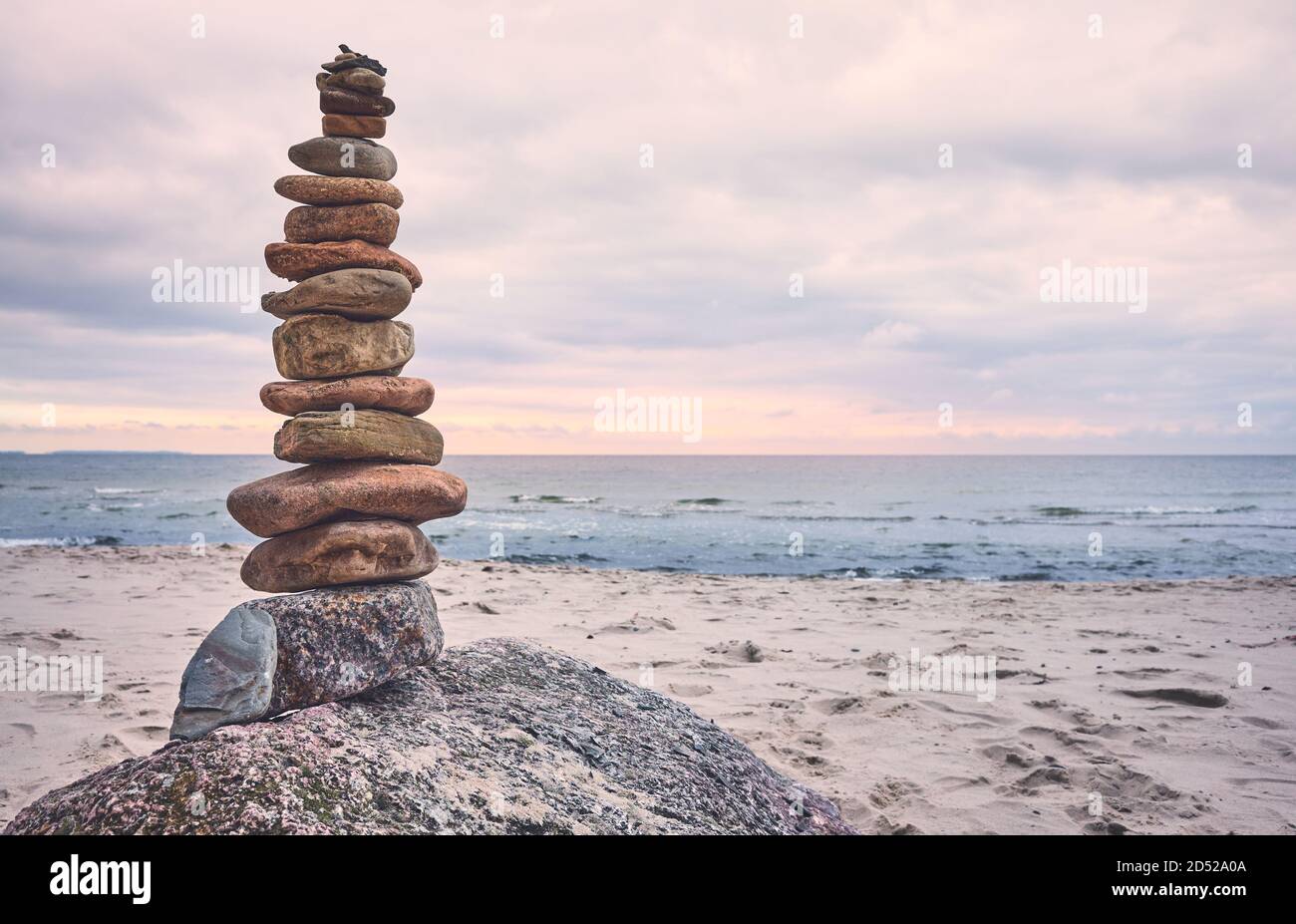 Piramide di pietra su una spiaggia, zen, armonia e concetto di equilibrio, tonalità di colore applicato. Foto Stock