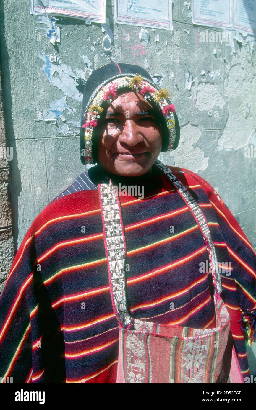 Questo venditore di tessuti indigeni di Tarabuco proviene da una località famosa per la sua tessitura. Il suo cappello in pelle imita un casco di conquistador, parlando volumi della conquista spagnola quasi 500 anni fa. La Paz, capitale della Bolivia. Foto Stock
