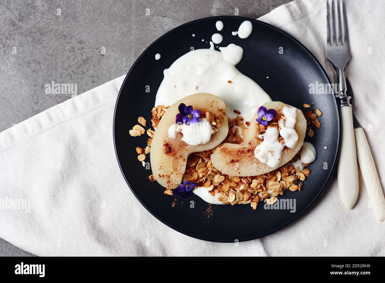 Pera in camicia con cannella, yogurt e granola di avena. Foto Stock