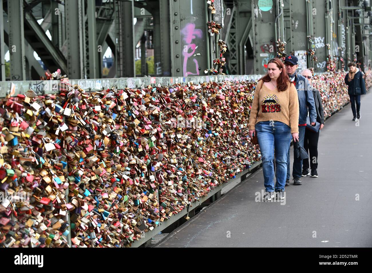 Colonia, Germania, 2020. Le persone che camminavano passavano migliaia di chiuse d'amore sul ponte Hohenzollern che attraversava il fiume Reno Hohenzollernbrücke Foto Stock