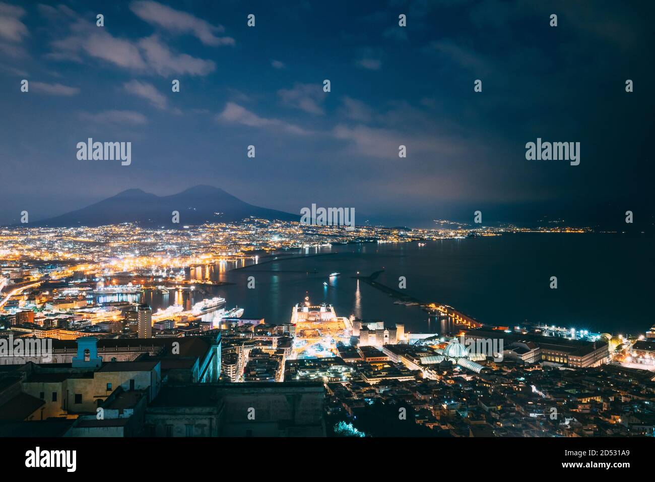 Napoli, Italia. Top Vista del paesaggio urbano skyline di Napoli con il Vesuvio e il Golfo di Napoli in background nelle illuminazioni serali o notturne Foto Stock