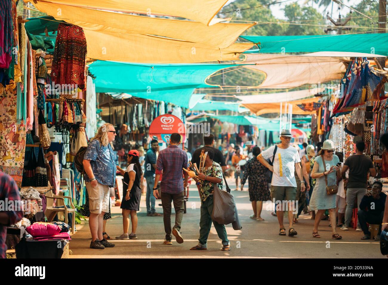 Anjuna, Goa, India. Il venditore di strumenti musicali vende i flauti indiani tradizionali ad UN turista nel mercato di Anjuna. Foto Stock