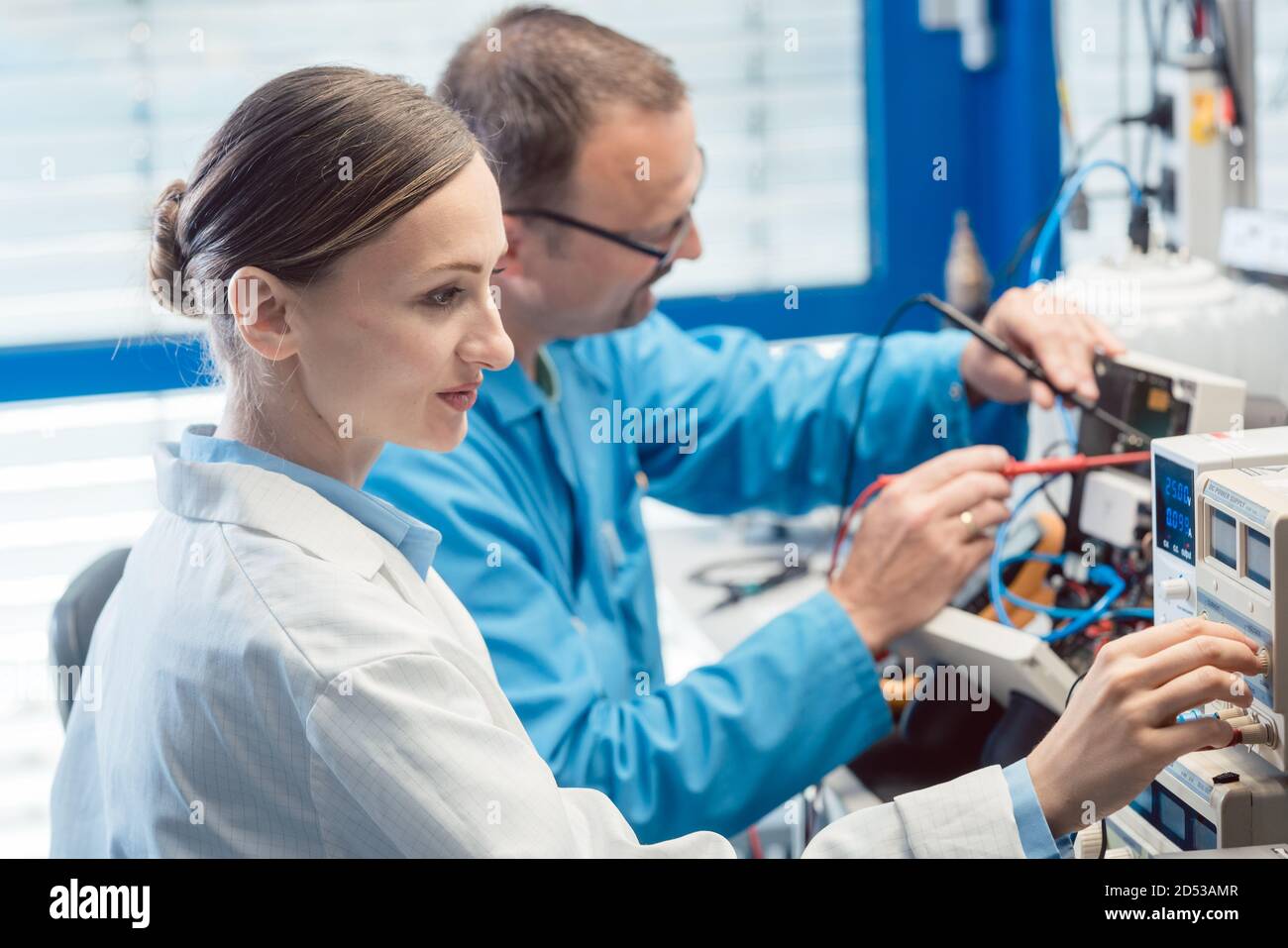 Due ingegneri elettronici sul banco di prova che misurano un nuovo prodotto Foto Stock