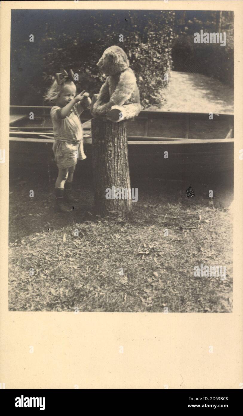 Kleines Mädchen mit ihrem Teddybären, Ruderboot, Baumstamm | utilizzo in tutto il mondo Foto Stock