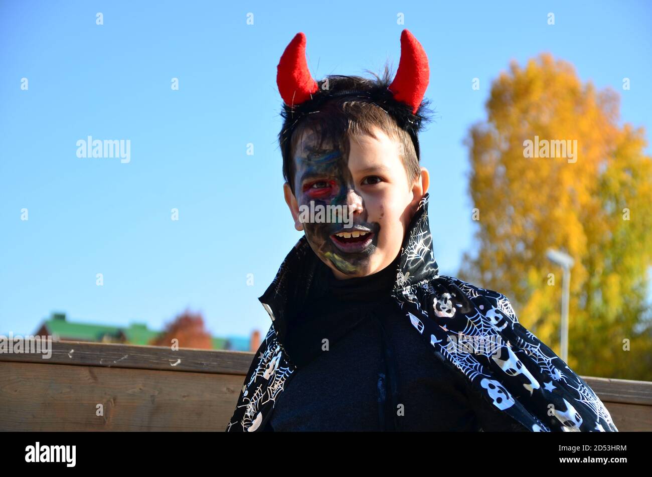 bambino divertente in costume halloween diavolo con corna e tridente su un  ragazzo di sfondo di legno scuro con trucco nero per halloween, zombie Foto  stock - Alamy