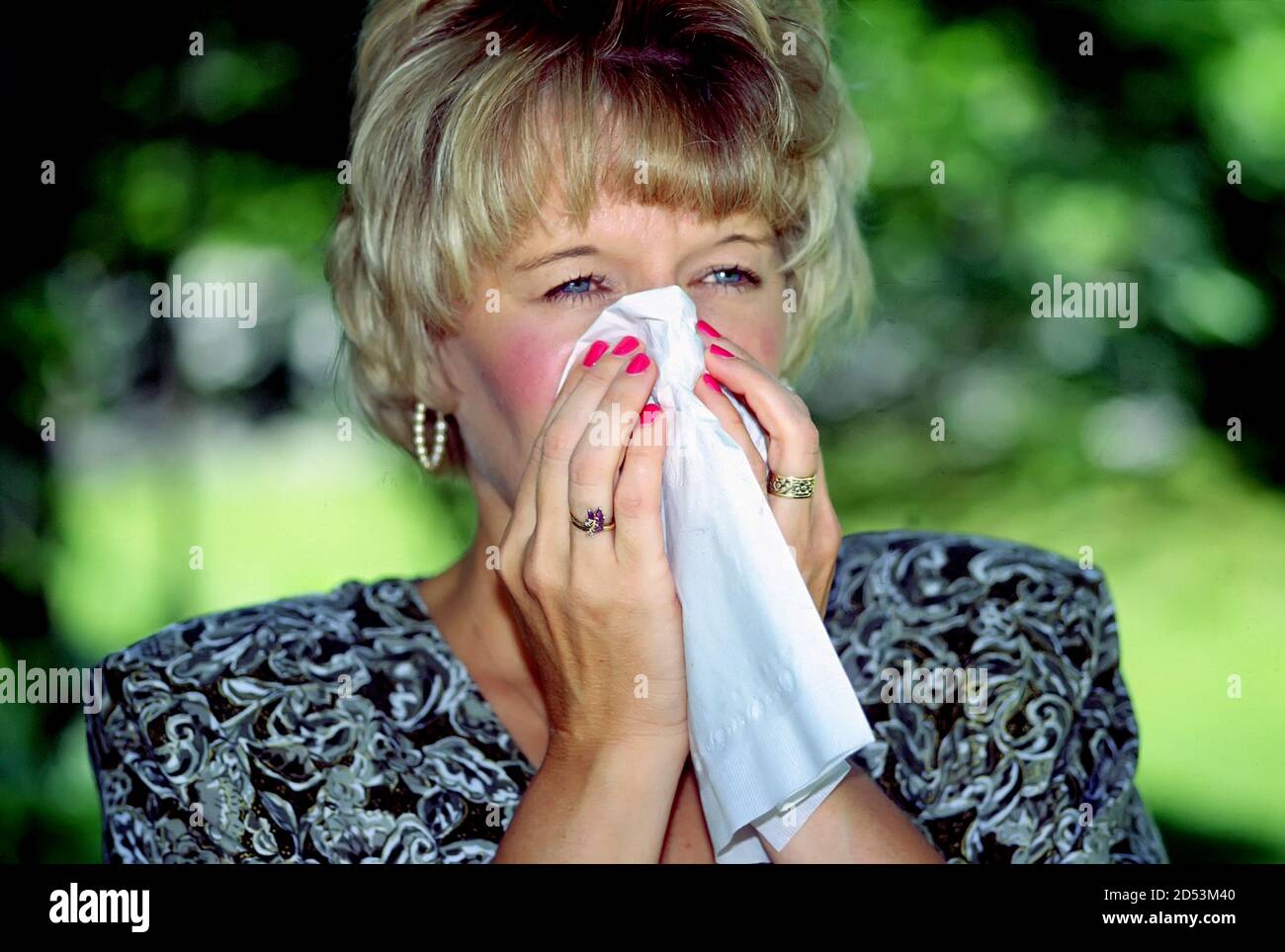 Donna adulta con un raffreddore o la canna fumaria nel atto di starnuti a causa di allergie Foto Stock