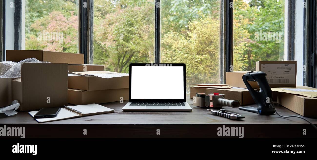 Tavolo con computer portatile mock up schermo e scatole, ecommerce online store spedizione. Foto Stock