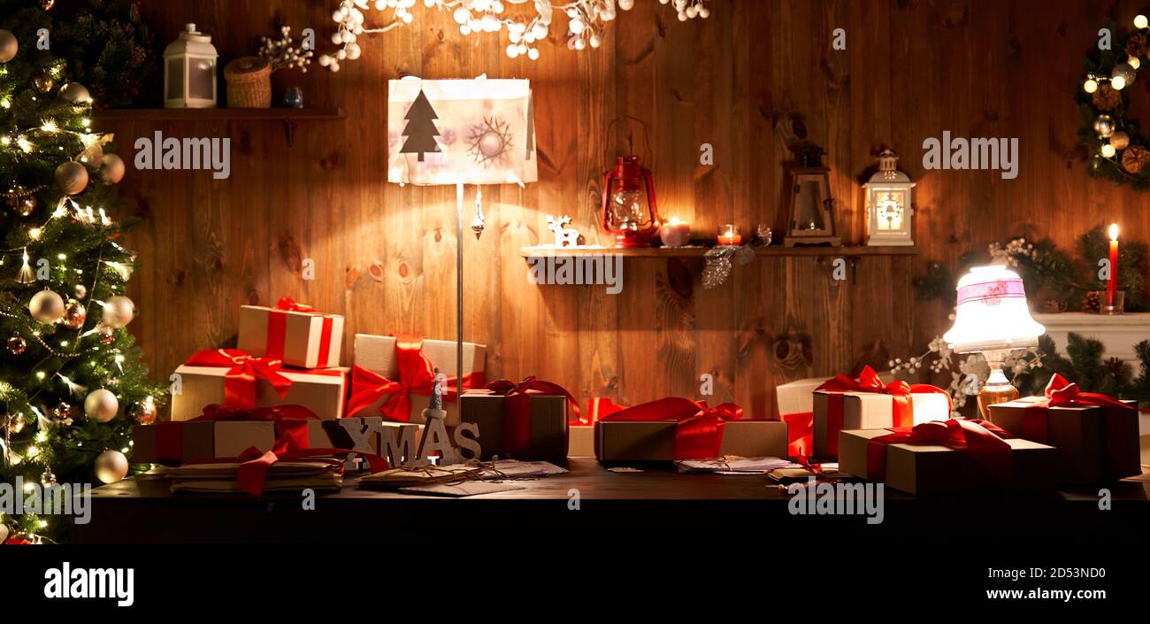 Tavolo decorato xmas con regali di Natale e albero in casa Santa accogliente, banner. Foto Stock